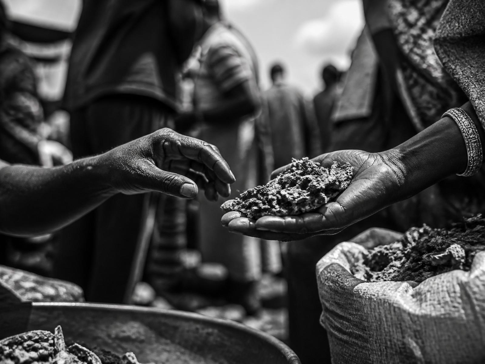 Hands exchanging goods at an African marketplace